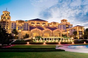 A large, luxurious hotel with a prominent entrance and a well-maintained garden. - #2750 Cozy Resort 4/3.5 2 Masters Disney Universal (Kissimmee)