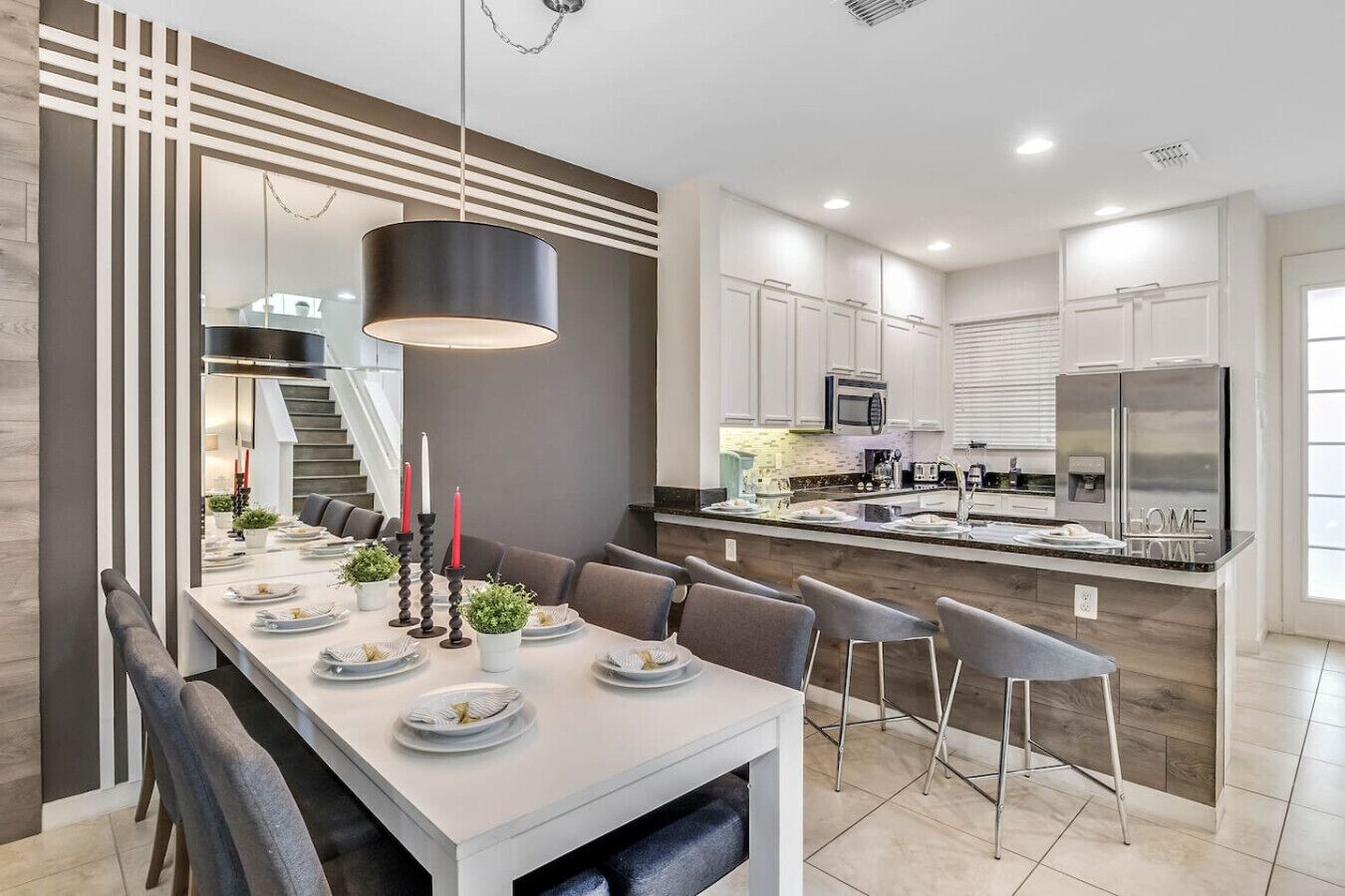 A modern kitchen with white cabinets, stainless steel appliances, and a central island.