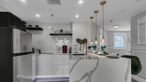A modern kitchen with a central island, stainless steel appliances, and pendant lighting. - 1902 Luxury 2BD/2BA Lakefront• I-Drive+Universal (Orlando)