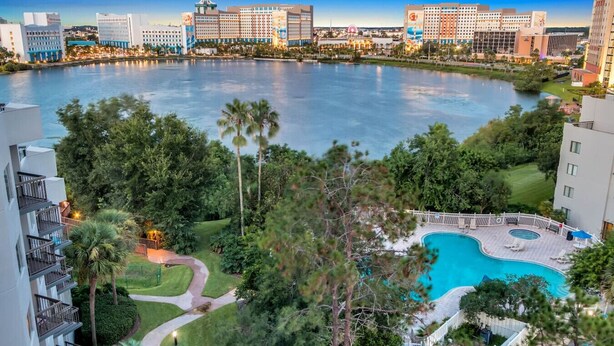 A hotel with a pool surrounded by lush greenery and a view of a large body of water. - 1902 Luxury 2BD/2BA Lakefront• I-Drive+Universal (Orlando)
