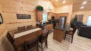 Ein Holzblockhaus mit Küche, Essbereich und einer Sitzecke.