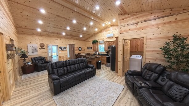 Ein Blockhaus-Interieur mit Wohnzimmer, Küche und Essbereich.