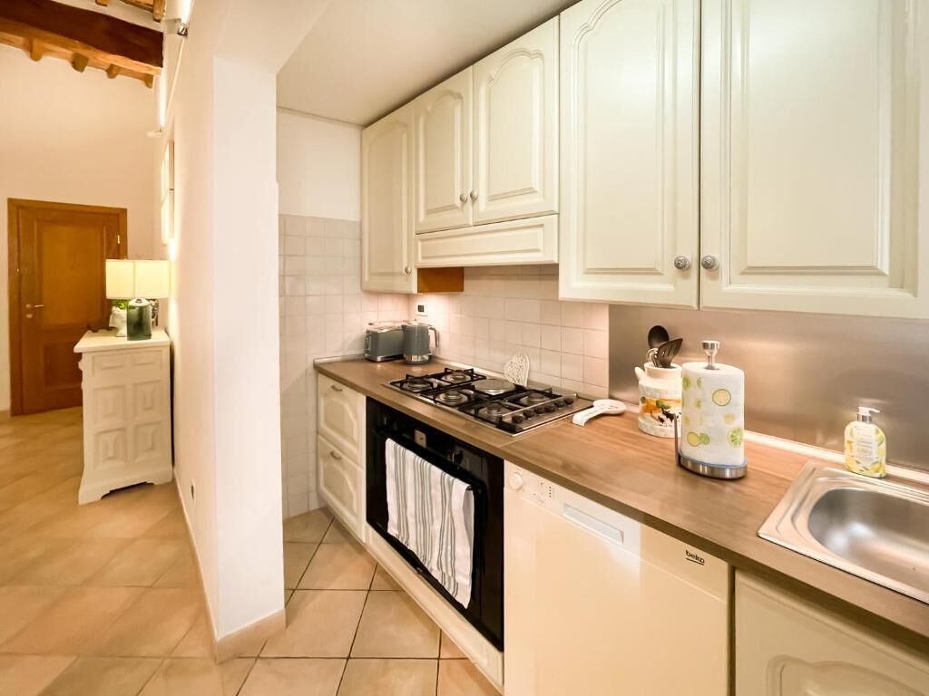A kitchen with white cabinets, a stove, a dishwasher, and a sink.