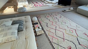 A cozy attic bedroom with a sloped ceiling, a bed, a TV, and a large decorative rug. - House on the Champagne Route - 1h10 from Paris (Crézancy)