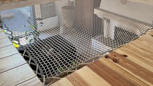 A room with a wooden floor, a mesh table, a sofa, and a TV. - House on the Champagne Route - 1h10 from Paris (Crézancy)