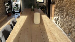 A wooden dining table with chairs, a vase, and hanging paper lanterns in a rustic room with stone walls and a wooden ceiling. - House on the Champagne Route - 1h10 from Paris (Crézancy)