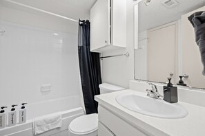 A modern bathroom with a bathtub, toilet, and sink. - Quiet Central Austin Getaway Near UT (Austin)