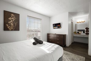 A bedroom with a large bed, a dresser, a vanity with a mirror, and a framed picture on the wall. - Quiet Central Austin Getaway Near UT (Austin)