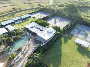 An aerial view of a resort with a swimming pool, tennis courts, and a restaurant. - Oceanfront End Unit, Lanai Steps from the Sand, Pool & Pickleball -Unit 3 (Koloa)