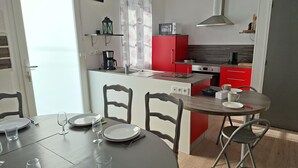 Eine kleine Küche mit roten Schränken, einer Mikrowelle und einer Kaffeemaschine.