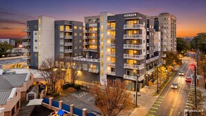 A multi-story building with the name 'DORSEN' on the facade, featuring balconies and illuminated windows. - Stylish 2B2B Apartment in Downtown ATL (Atlanta)