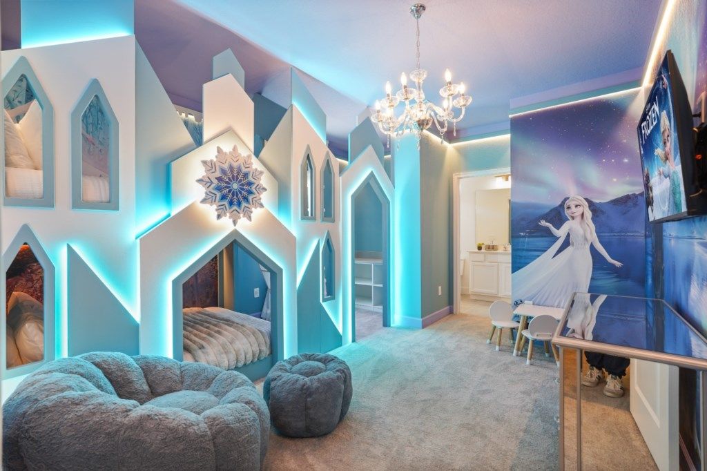 Een kinderkamer met een kasteelthema, met een bed, zithoek en een muurschildering.