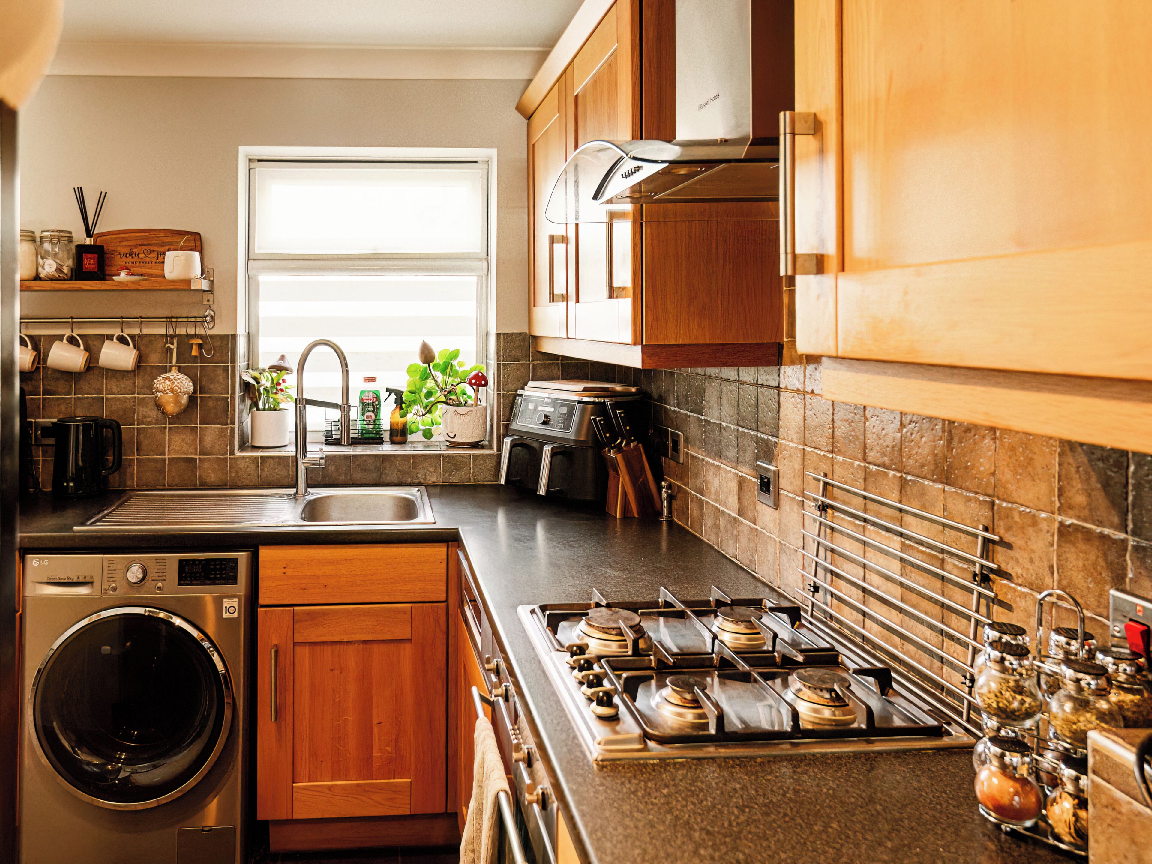 A kitchen with wooden cabinets, a stainless steel sink, a built-in oven, and a coffee maker.