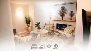 A cozy living room with a fireplace, a round table, and comfortable seating.