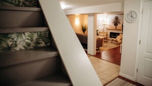 A staircase leading to a living area with a sofa, a lamp, and a clock on the wall.