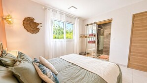 Une chambre avec un lit, une fenêtre avec des rideaux, un espace douche et une armoire.