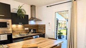 Une cuisine moderne avec une table en bois, des chaises et un four encastré.