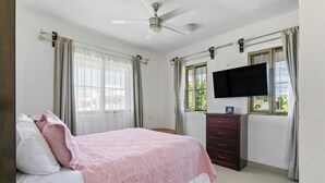 A bedroom with a bed, a dresser, a television, and a ceiling fan. - Luna de Plata (Playa del Carmen)