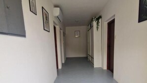 A hallway with white walls, grey flooring, and doors on both sides. - Three Bedroom Apartment With Balcony And Sea View (Karlobag)