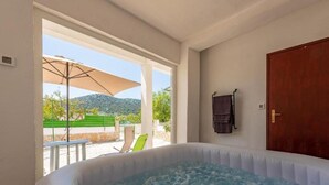 Ein Zimmer mit Whirlpool, einer Tür und Blick ins Freie.