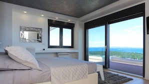 Een moderne slaapkamer met een groot bed, een bureau en uitzicht op de omgeving.