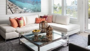 A modern living room with a white sofa, a glass coffee table, and a ceiling fan. - Swimming Pool / Boat Dock / Close to Key West (Sugarloaf)