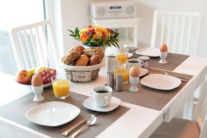 A breakfast table set with bread, eggs, fruit, and juice. - Sometimes you just need a little time out. (Gelbensande)