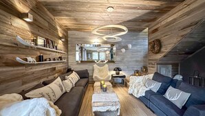 A cozy, log-furnished living room with a sofa, a coffee table, and a fireplace. - Chalet-Nashira-Deluxe-Private Bathroom-Terrace (Bolquère)