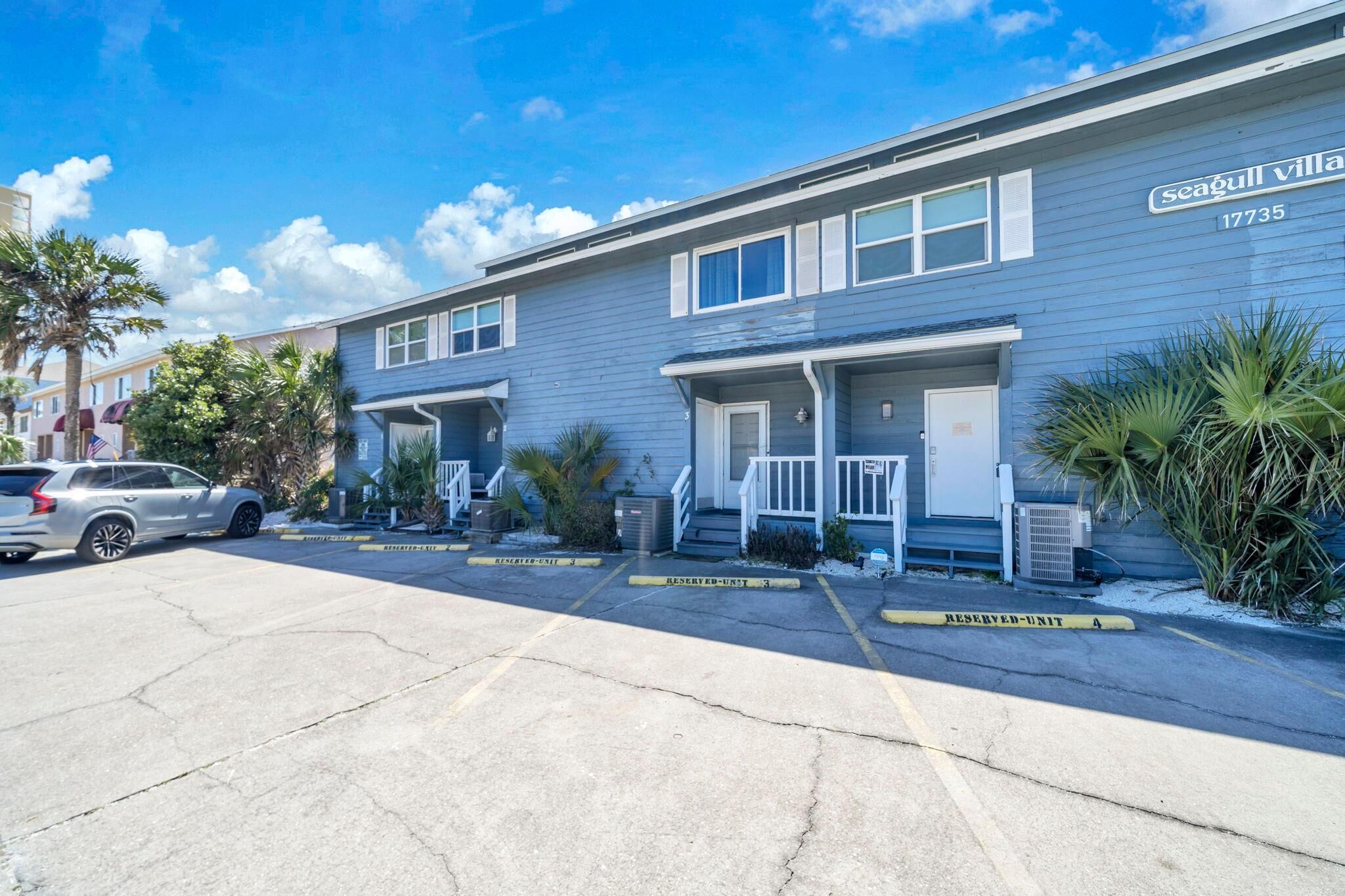 A row of Seagull Village townhouses with a parking lot in front.