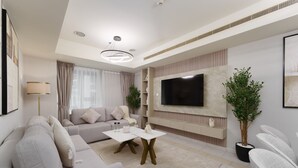 Un salon moderne avec un canapé, une table basse, un téléviseur et des plantes décoratives.