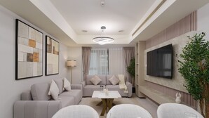 Un salon moderne avec un canapé, une table basse et un coin repas aménagé pour quatre personnes.