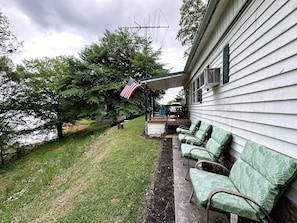 A house with a porch, outdoor seating, and an American flag.