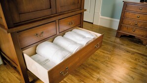 Une commode en bois dotée de nombreux tiroirs et d’un placard intégré pour le linge de maison.