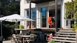 Une maison moderne à deux étages dotée d’une piscine, d’un espace salon extérieur et d’un patio couvert.