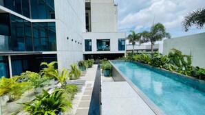 A modern building with a pool, surrounded by lush greenery and a clear sky. - Executive studio close to National Stadium and AirPort (Rohrmoser)