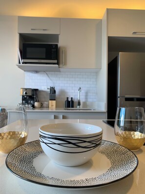 A modern kitchen with white cabinets, a microwave, and a refrigerator. - Executive studio close to National Stadium and AirPort (Rohrmoser)