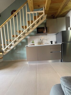 A modern kitchen with a built-in microwave, stainless steel appliances, and a wooden staircase. - Cozy Apartment in pleasant Bayahibe 4 minutes to the beach (Bayahibe)
