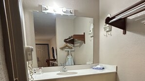 A bathroom with a vanity, mirror, and a towel rack. - Lodge Inn Extended Stay (Goldsboro)
