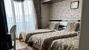 Une chambre d’hôtel avec deux lits, un bureau et une chaise.