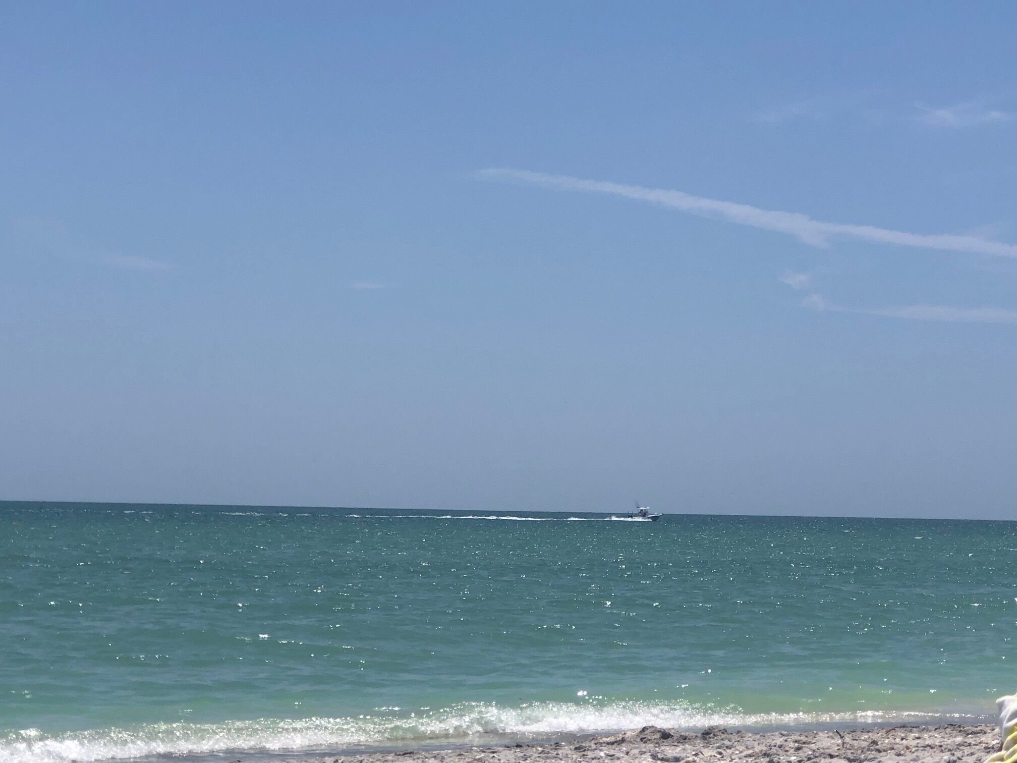 Una playa con cielos despejados y aguas tranquilas.