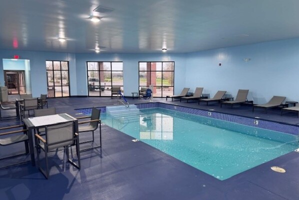 A swimming pool with lounge chairs, a table, and chairs. - Hawthorn Extended Stay by Wyndham Miamisburg Dayton South (Miamisburg)