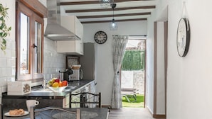 Una cocina moderna con comedor, un reloj y vistas al jardín.