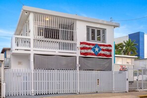 Ein zweistöckiges Gebäude mit Balkon, Flagge und geschlossenem Eingang.