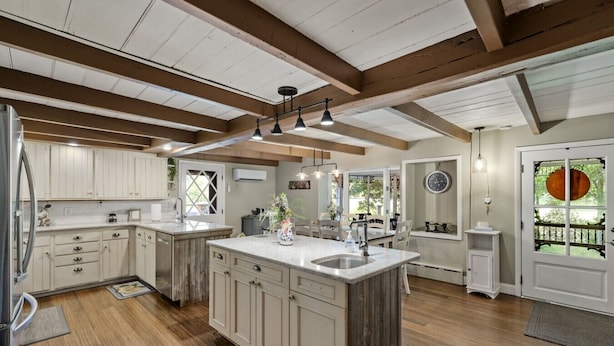 A spacious kitchen with wooden beams, a large island, and a view to the outside. - Pool | Hot Tub | 3 Min to Lake | Pets Allowed (Auburn)
