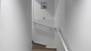A staircase with wooden steps and white handrails. - Mayfair Suite (Airdrie)