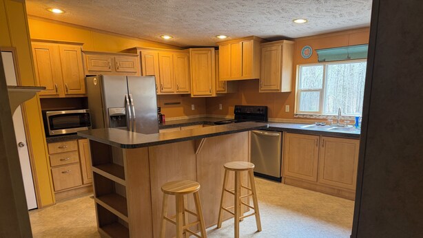A kitchen with wooden cabinets, a stainless steel refrigerator, a microwave, a dishwasher, and a window with a view. - 3-bedroom private house next to Windrock and Frozen Head State Park (Oliver Springs)