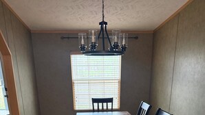 A dining room with a rectangular table and six chairs, a chandelier, and a window with blinds. - 3-bedroom private house next to Windrock and Frozen Head State Park (Oliver Springs)