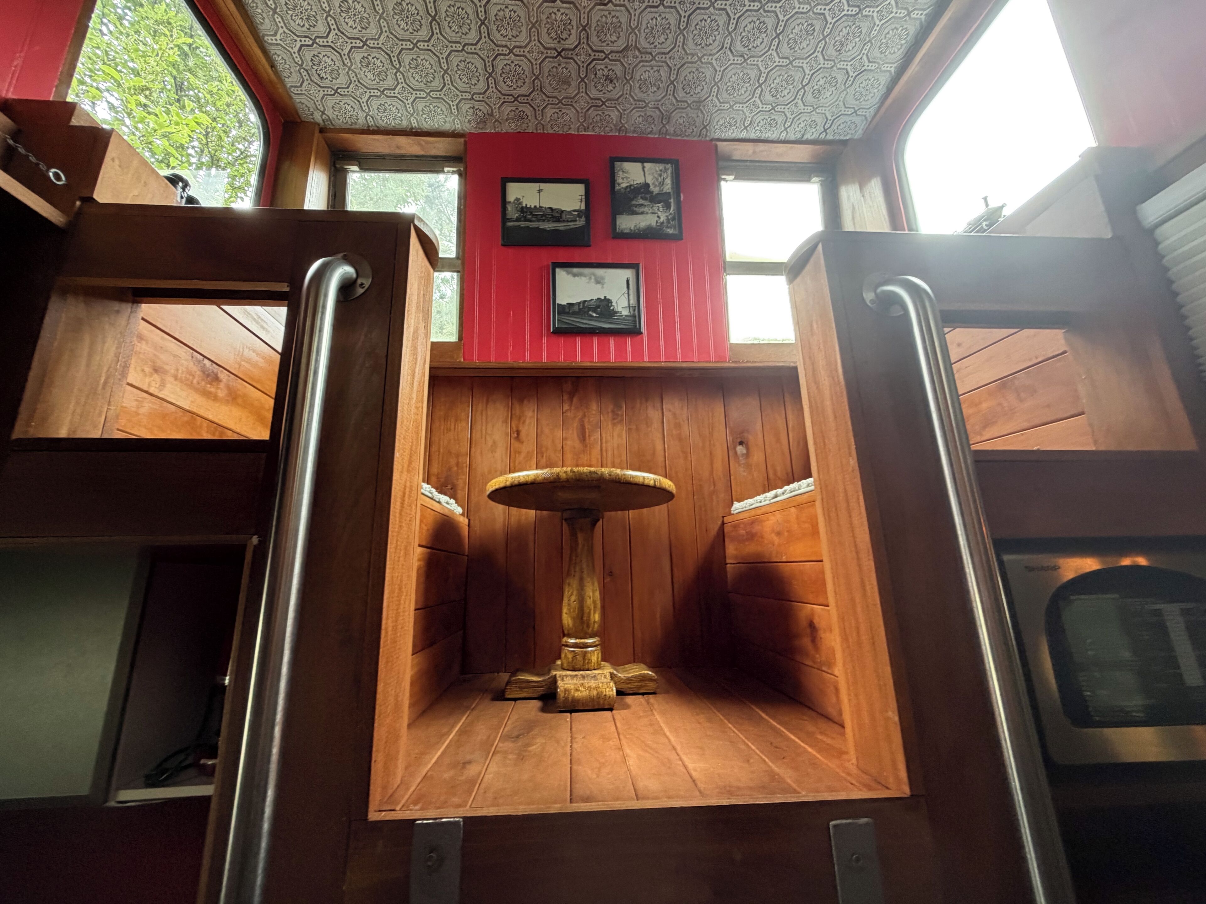 Un intérieur en bois avec une table centrale, des murs en bois et un plafond orné de motifs.