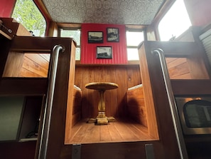 Un interior de madera con una mesa central, paredes de madera y un techo con diseño.