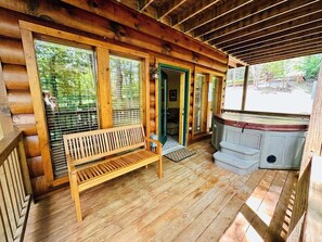 A wooden cabin with a porch, a bench, and a hot tub. - Campbell Station Beautiful!!! Authentic log cabin! hot tub outdoor fireplace (Gatlinburg)